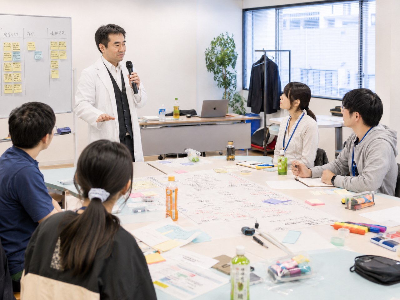 講師がホワイトボードの前で受講者に説明しているワークショップ形式のセミナー風景